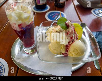 Das leckere Bananeneis mit der heißen Himbeermarmelade. Stockfoto