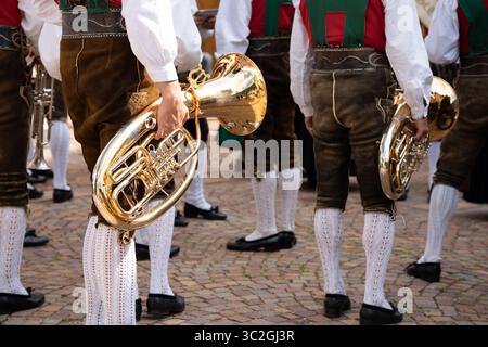 Männer in Lederhosen und traditioneller südtiroler Volkskleidung aus St. Christina, St. Christina, Gröden, während des jährlichen Folklorefestivals mit Blasinstrumenten im Sommer Stockfoto