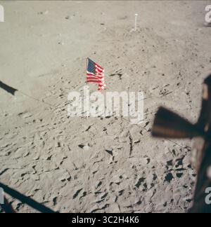 20. Juli 1969 - Mondoberfläche - die Flagge der Vereinigten Staaten, die auf der Oberfläche des Mondes aufgestellt wurde, dominiert dieses Foto aus dem Inneren des Mondmoduls (LM). Die Fußabdrücke der Astronauten Neil A. Armstrong und Edwin E. Aldrin Jr. fallen sehr deutlich hervor. Im Hintergrund befindet sich die Schwarzweiß-Mondoberfläche-Fernsehkamera, die die Apollo 11 Mondoberfläche (EVA) im Fernsehen ausstrahlte. Während die Astronauten Armstrong, Kommandeur, und Aldrin, Pilot des Mondmoduls, im Mondmodul (LM) „Eagle“ abstiegen, um die Region Meer der Ruhe des Mondes, Astronaut M, zu erkunden Stockfoto
