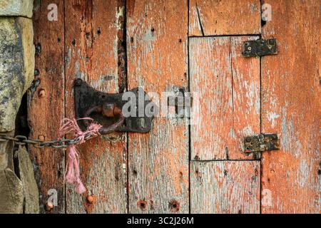 Abblätternde Farbe und alte Beschläge der Scheunentür, Scharniere usw. Stockfoto