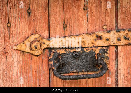 Abblätternde Farbe und alte Beschläge der Scheunentür, Scharniere usw. Stockfoto