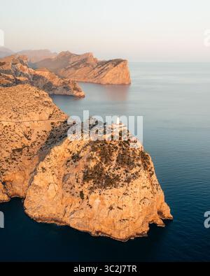 Blick aus der Vogelperspektive auf den zerklüfteten, sonnenverwöhnten Klippen von Cap de Formentor, wo das azurblaue Meer auf die krasse Schönheit der balearischen Landschaft trifft, Formentor, Balearen, Spanien. Stockfoto