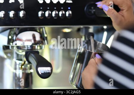 Cremona, Italien - 21. Juli 2025 Barista bereitet cremiges Espresso-Getränk mit einer professionellen Kaffeemaschine zu und schäumt Milch in einem Café auf Stockfoto