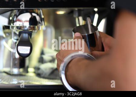 Cremona, Italien - 21. Juli 2025 Barista bereitet Kaffeegetränk mit Milchschaumkrug an der Espresso-Maschine vor Stockfoto