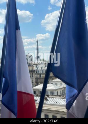 Paris Frankreich 9. Mai 2025. Malerischer Blick auf den Eiffelturm zwischen zwei französischen Flaggen in Paris. Die ikonische Struktur ist vor dem wunderschönen Himmel festgehalten, h Stockfoto