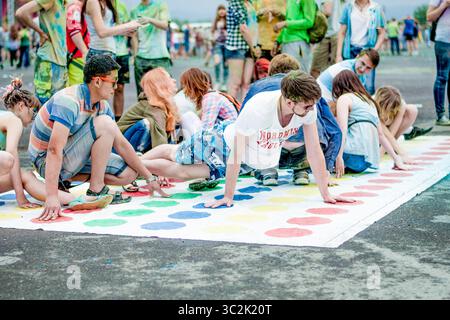Lustige Leute spielen draußen im Sommer Twister Stockfoto