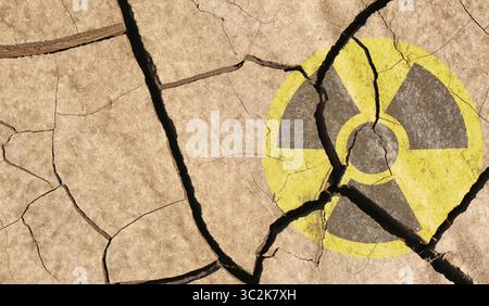 Gelbes radioaktives Zeichen auf gerissener trockener Erde, Draufsicht. Radiologische Verschmutzung Stockfoto