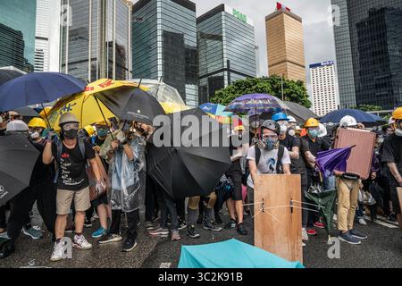 1. Juli 2019: Hongkong, China: Anti-Regierungs-Demonstranten benutzen Regenschirme und selbstgemachte Schilde, um sich während der Auseinandersetzung vor der Polizei zu schützen. Tausende von regierungsfeindlichen Demonstranten standen während des 22. Jahrestages der Rückkehr Hongkongs zur chinesischen Herrschaft mit der Polizei und besetzen wichtige Straßen rund um den Regierungskomplex Hongkongs. (Credit Image: © Geovien so/SOPA Images via ZUMA Wire) Stockfoto