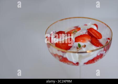 Frisches Erdbeerdessert mit Schlagsahne in einem eleganten Glas, Blick von oben. Süßes und erfrischendes Sommererlebnis. Stockfoto