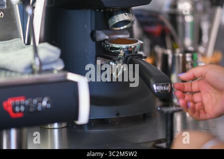 Cremona, Italien - 21. Juli 2025 Nahaufnahme Einer Barista Grinding Coffee Beans in Einem Portafilter für die Zubereitung von Espresso Stockfoto