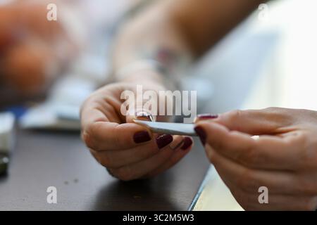 Cremona, Italien - 21. Juli 2025 Großaufnahme einer Person, die vorsichtig eine Marihuana-Zigarette mit einem Papierrollen und einer Cannabisblume rollte Stockfoto