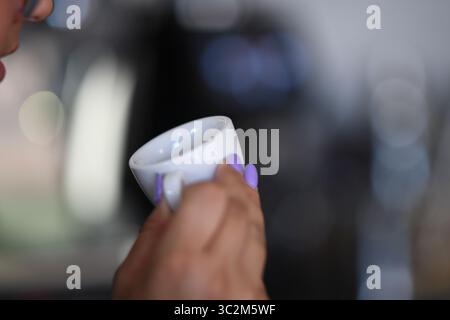 Cremona, Italien - 21. Juli 2025 Eine Frau schlürft einen kleinen Espresso-Becher und genießt eine Kaffeepause am Morgen Stockfoto