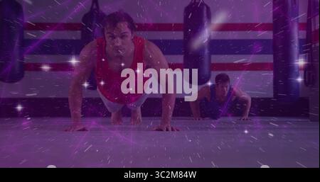 Zwei athletische Männer im Kampfsport-Fitnessstudio, schwere Boxsäcke und lila Licht. Kraft, Fitness, Training, Sport, Entschlossenheit, VIG Stockfoto