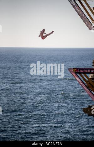 14. Juli 2019 – Libanon – der polnische Hochtaucher Kris Kolanus springt während des Wettkampfs aus 27 m Höhe bei Rauche Rocks. Im Rahmen einer von RedBull gesponserten Welttournee nehmen Hochtaucher aus aller Welt an Klippensprüngen Teil. Aus Höhen von 20 m sprangen sie auf starke Winde und raue See. (Kreditbild: © Elizabeth Fitt/SOPA Images via ZUMA Wire) Stockfoto