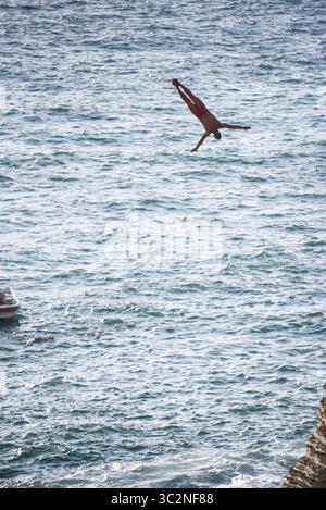 14. Juli 2019 – Libanon – der polnische Hochtaucher Kris Kolanus springt während des Wettkampfs aus 27 m Höhe bei Rauche Rocks. Im Rahmen einer von RedBull gesponserten Welttournee nehmen Hochtaucher aus aller Welt an Klippensprüngen Teil. Aus Höhen von 20 m sprangen sie auf starke Winde und raue See. (Kreditbild: © Elizabeth Fitt/SOPA Images via ZUMA Wire) Stockfoto