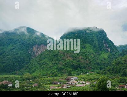 Aus der Vogelperspektive sehen Sie Nebel, Wolken und Nebel, die über einem üppigen tropischen Gebirge hängen Stockfoto
