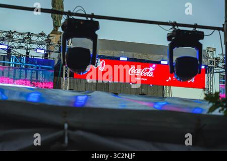 Coca-Cola Real Magic Logo auf rotem LED-Bildschirm über der Konzertbühne mit Beleuchtungsbühne. Coca-Cola The Voice Happy Energy Tour 2025, Musik von Stockfoto
