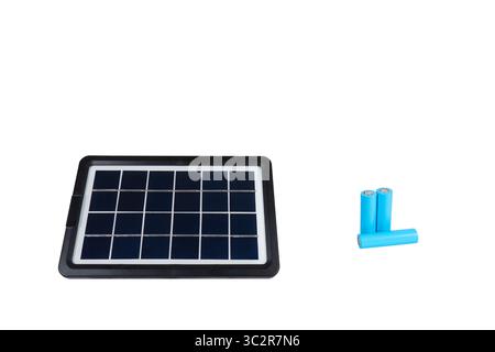 Tragbares Solarmodul neben drei blauen zylindrischen Batterien auf einem sauberen weißen Hintergrund Stockfoto
