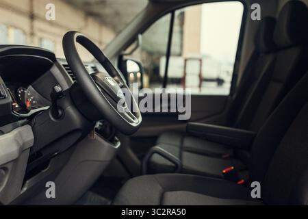 Moderner Innenraum. Weiße Ledersitze und Armaturenbrett im modernen SUV. Ansicht auf der Fahrerkonsole von der hinteren Sitzreihe Stockfoto