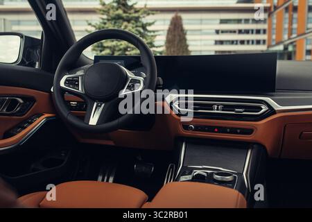 Moderner Innenraum. Weiße Ledersitze und Armaturenbrett im modernen SUV. Ansicht auf der Fahrerkonsole von der hinteren Sitzreihe Stockfoto