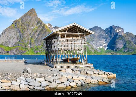 Holzgestelle zum Aufhängen von Kabeljau zum Trocknen vor dem Berg im Dorf Sakrisoy, Lofoten, Norwegen Stockfoto