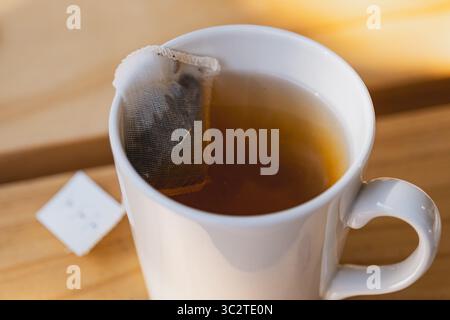 Teebeutel in einer weißen Keramikschale auf einem Holztisch Stockfoto