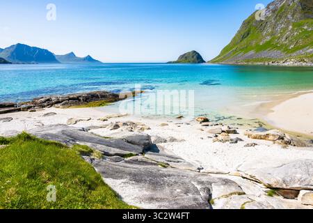 Kristallklares Meerwasser am Haukland-Strand und Blick auf die Berge im Sommer, Lofoten-Inseln, Norwegen Stockfoto