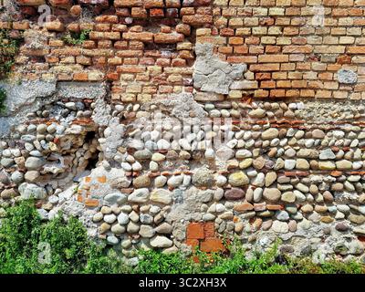 Textur einer alten Mauer aus Ziegeln und Kopfsteinpflaster in der mittelalterlichen Stadt Bassano-del-Grappa, Italien Stockfoto