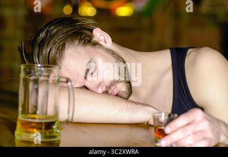 Alkoholisch. Einsamer betrunkener Mann, der im Restaurant trinkt. Depressiver betrunkener Mann mit einem Glas Alkohol. Nachtleben Stress führt zu sucht. Betrunkener Kerl im Pub Stockfoto