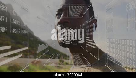 Interagierender Mann, der Pullover und Ohrstöpsel trägt und schwimmende Karten im Bergtal ansieht, AR-Ansicht Stockfoto