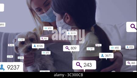 Hund Mutter-Tochter mit Gesichtsmasken halten, zu Hause auf Sofa sitzen, digitale Overlays schwebend Stockfoto