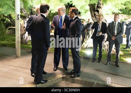 24. August 2019, Biarritz, Frankreich: US-Präsident Donald Trump, Gesprächspartner mit dem britischen Premierminister Boris Johnson, links, und dem französischen Präsidenten Emmanuel Macron, rechts, nach dem G7 Leadersâ€™-Dinner im Leuchtturm von Biarritz am 24. August 2019 in Biarritz, Frankreich. (Bild: © Shealah Craighead Via ZUMA Wire) Stockfoto