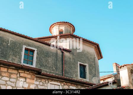 Fragment des alten Kirchengebäudes mit Steinmauern und roten Dachziegeln. Stadt Omisalj, Insel Krk, Kroatien. Stockfoto