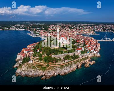Rovinj, Kroatien - aus der Vogelperspektive auf die Altstadt von Rovinj mit der Kirche St. Euphemia und dem dramatischen goldenen und blauen Himmel an einem sonnigen Sommertag in Istrien, Stockfoto