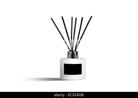 Duftdiffusor mit Schilf und ätherischen Ölen in einer weißen Flasche auf weißem Hintergrund und leerem schwarzen Etikett Stockfoto