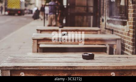 Traditionelle Pub-Möbel im Freien mit Holztischen in einladender Umgebung Stockfoto