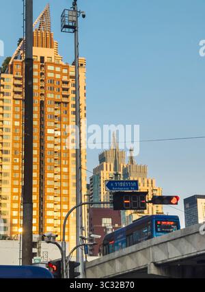 Bangkok,Thailand-07. April 2024-später Nachmittag, Sonnenlicht aus niedrigem Winkel wird zufällig von Hochhäusern reflektiert, während der Stadtverkehr im Schatten läuft Stockfoto