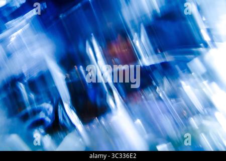 Ein dynamisches, abstraktes Bild mit Streifen aus blauem und blauem Licht mit Bewegungsunschärfe und weißem Licht in Lichtern. Stockfoto