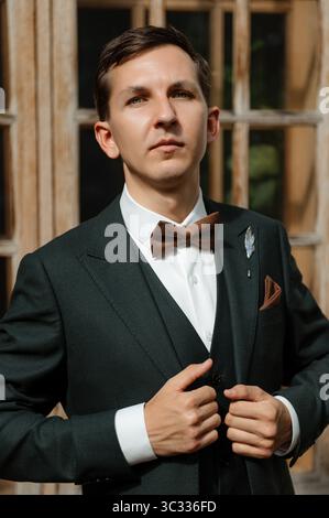 Eleganter Mann posiert in klassischem Anzug mit Bowtie in einem Vintage-Setting Stockfoto