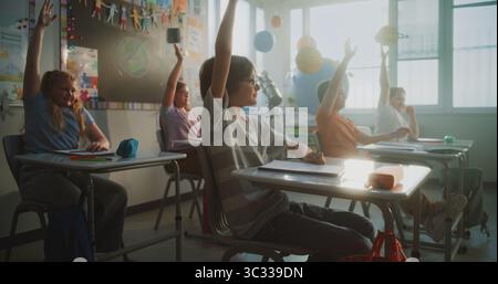 Grundschüler sitzen an den Schreibtischen, hören den Vorträgen des Lehrers zu und heben die Hände, um die richtige Antwort zu geben. Team von Smart Diversity Kids studiert Wissenschaft, Geographie im modernen Klassenzimmer. Stockfoto