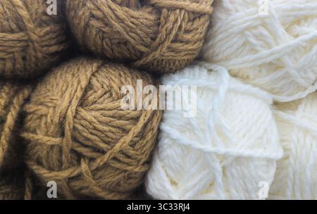 Braune und weiße Garnbällchen in Nahaufnahme bei weichem natürlichem Licht Stockfoto