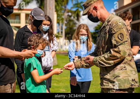 15. März 2021: Schofield Barracks, Hawaii, USA – Oberst Joshua Bookout, 3. Infanterie-Brigade Combat Team, 25. Infanterie-Division-Kommandant überreicht am 15. März 2021 eine Brigade-Münze an die Kinder von Ed Ray, einem Mitglied der Gold Star-Familie in F-Quad, Schofield Barracks Hawaii. Ed Ray ist der Zwillingsbruder von 1. Lieutenant Clovis T. Ray, einem Anführer des Gewehrzuges, der dem 2. Bataillon, 35. Infanterieregiment zugewiesen wurde, als er am 15. März 2012 an Wunden starb, die er während eines feindlichen Angriffs mit einem improvisierten Sprengsatz erlitten hatte, als er auf Patrouille im Pech River in der Provinz Kunar, Afghanistan, starb. (Kreditbild: © U.S Stockfoto
