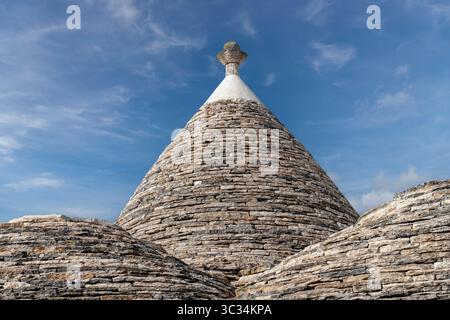 Nahaufnahme der charakteristischen konischen Steindächer von Trulli-Häusern in der Stadt Albarobello, Apulien, Italien mit blauem Himmel als Hintergrund Stockfoto