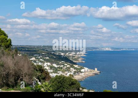 Panoramablick auf hoher Ebene entlang der Küste in der Nähe von Tricase Porto, Lecc, Italien mit blauem Wasser und weißem wolkenblauem Himmel Stockfoto