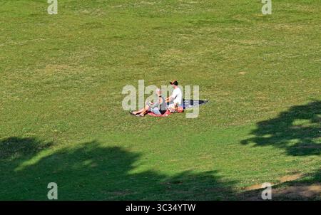 RIO DE JANEIRO, BRASILIEN - 19. Juni 2025: Zwei Männer sitzen auf dem Rasen in Quinta da Boa Vista Stockfoto