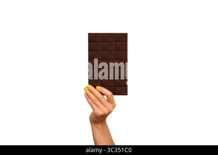 Die Hand der Frau hält eine dunkle Schokoladenriegel isoliert auf weiß. Stockfoto