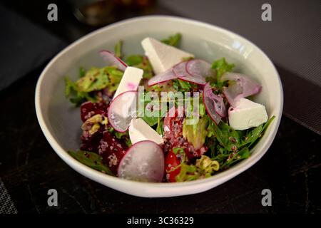 Frischer und lebendiger Salat mit gemischtem Grün, Radieschen, Quinoa und Käse, perfekt für eine gesunde Mahlzeit Stockfoto