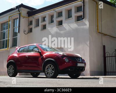 Bukarest, Rumänien – 13. Juli 2025: Vorderansicht des roten Autos von Nissan Juke, der in der Nähe des Gebäudes geparkt ist Stockfoto