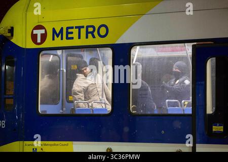 17. Februar 2021 – Minneapolis, Minnesota, USA – Polizeibeamte der Metro Transit sprechen mit einer Person, die sich offenbar weigert, von einem außer Betrieb befindlichen Zug der Blue Line auszusteigen. Polizeibeamte der Metro Transit bringen Passagiere seit März 2020 aus den außer Betrieb befindlichen Zügen der 38th Street Station ab, um ihre Rückkehr in die Betriebs- und Wartungseinrichtung zu beschleunigen, die etwas mehr als eine Meile vom Bahnhof entfernt ist. Das System ist ein Zufluchtsort für die ungeschützten in den Twin Cities, besonders im Winter. (Kreditbild: © Henry Pan/ZUMA Wire/ZUMAPRESS.com) Stockfoto
