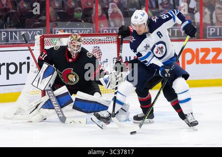 12. April 2021: Winnipeg Jets Mark Scheifele (55) versucht, den Puck gegen den Ottawa Senators Torwart Anton Forsberg (31) während des NHL-Spiels zwischen den Winnipeg Jets und den Ottawa Senators im Canadian Tire Centre in Ottawa, Kanada, umzuleiten. Daniel Lea/CSM.(Kreditbild: &Copy; Daniel Lea/CSM via ZUMA Wire) Stockfoto